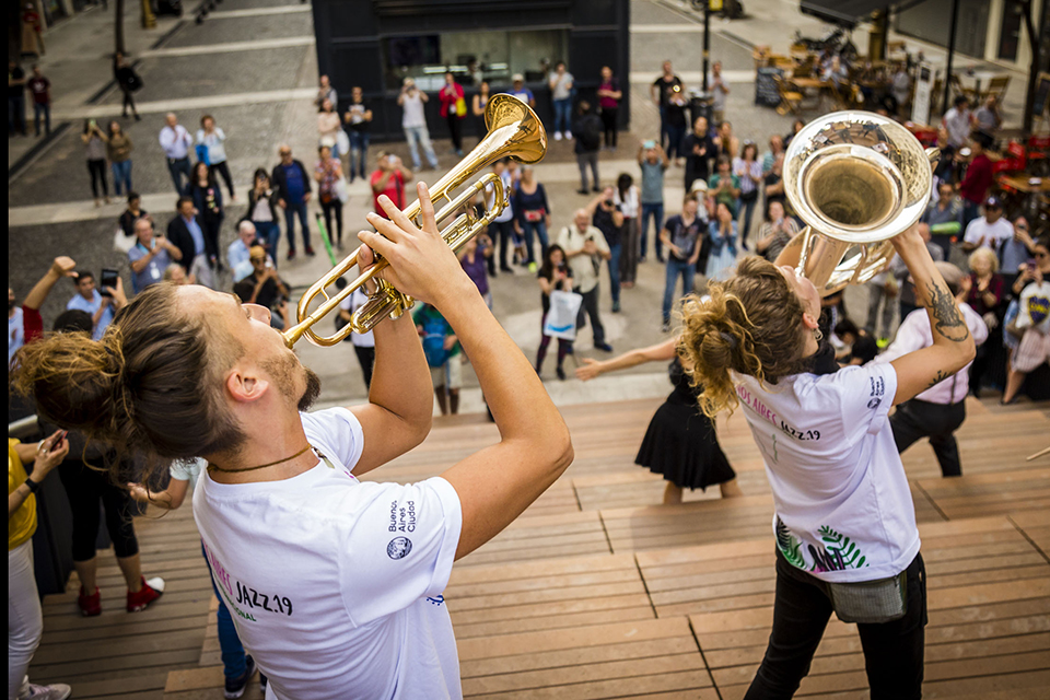 Musicos con instrumentos de vientos tocando frente al publico en Diagonal Norte y Av. 9 de Julio