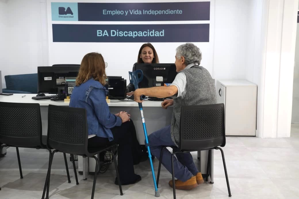 Una trabajadora de BA Discapacidad atiende a dos personas en un espacio de orientación laboral del programa Empleo y Vida Independiente.