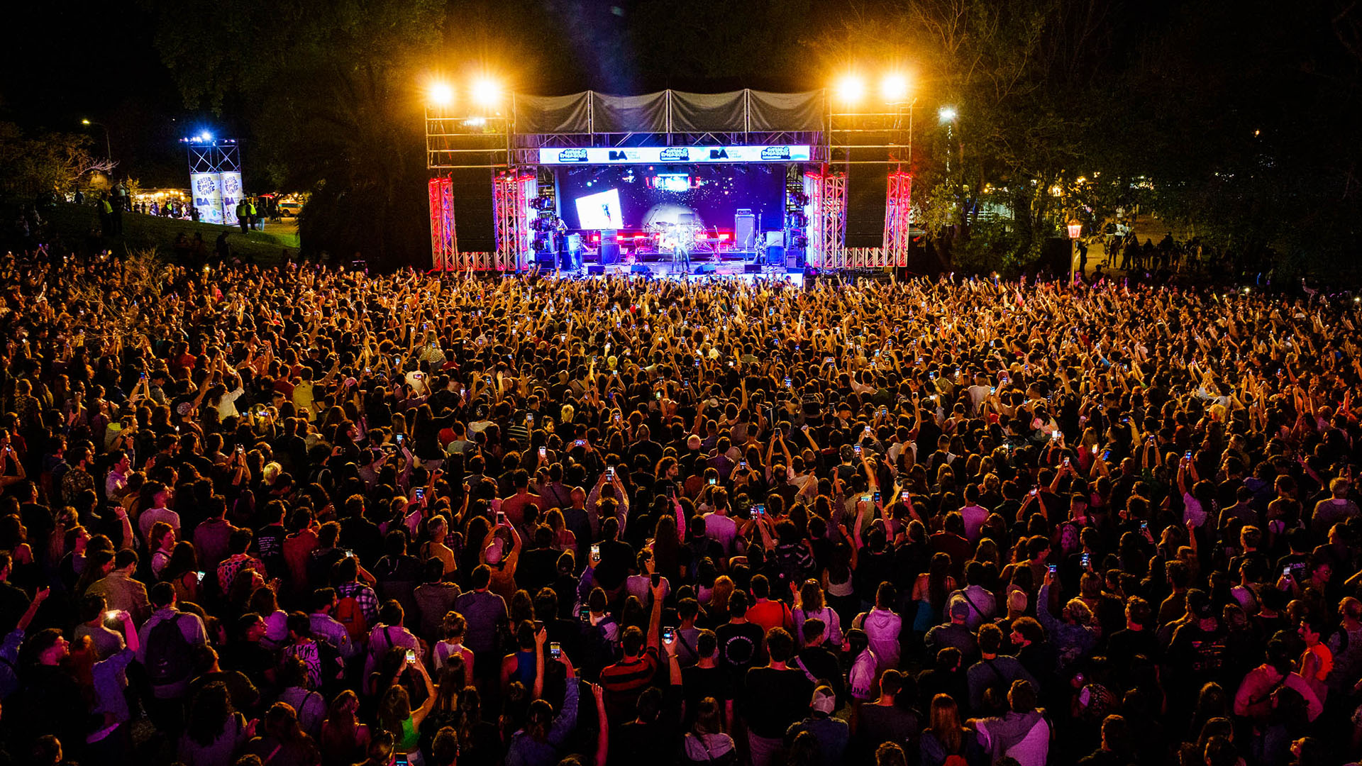 Escenario con banda tocando en Ciudad Emergente y publico 