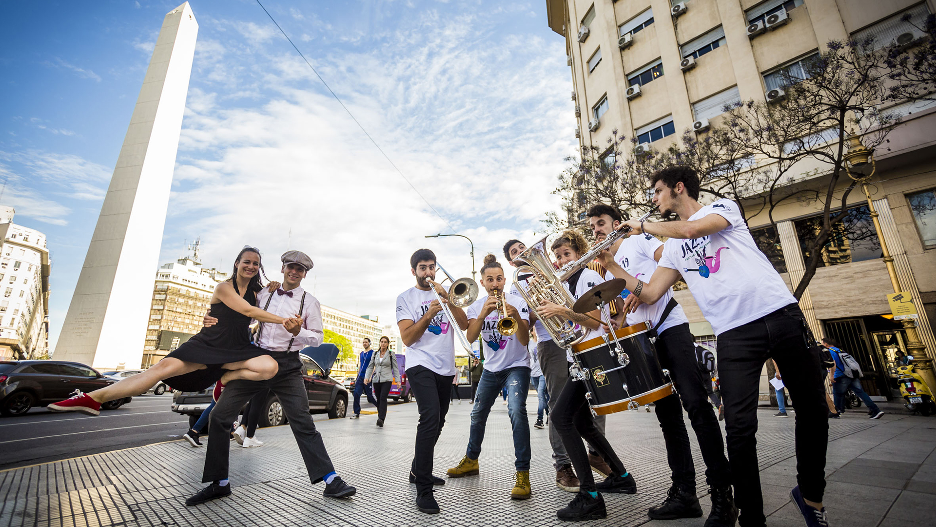 Musicos de jazz y pareja de baile sobre diagonal norte con Obelisco de fondo