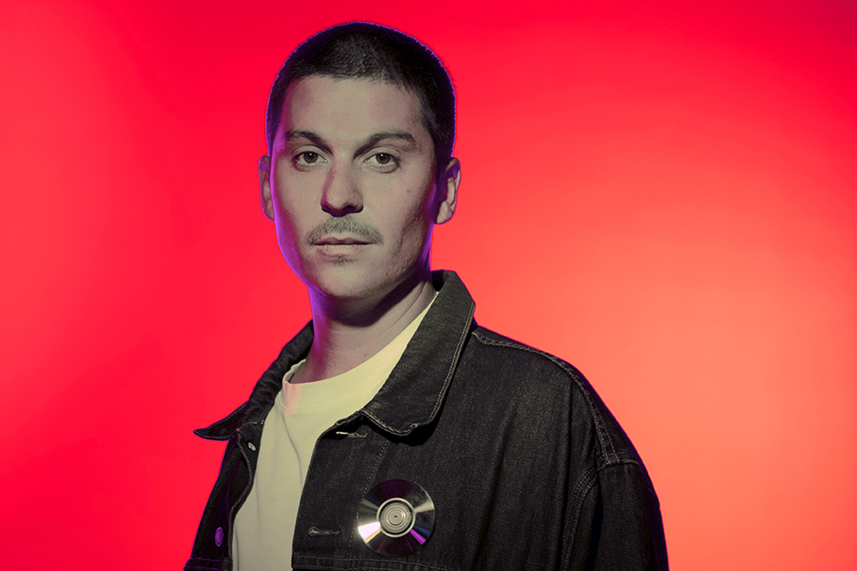 Retrato sobre fondo rojo del musico Santi Celli