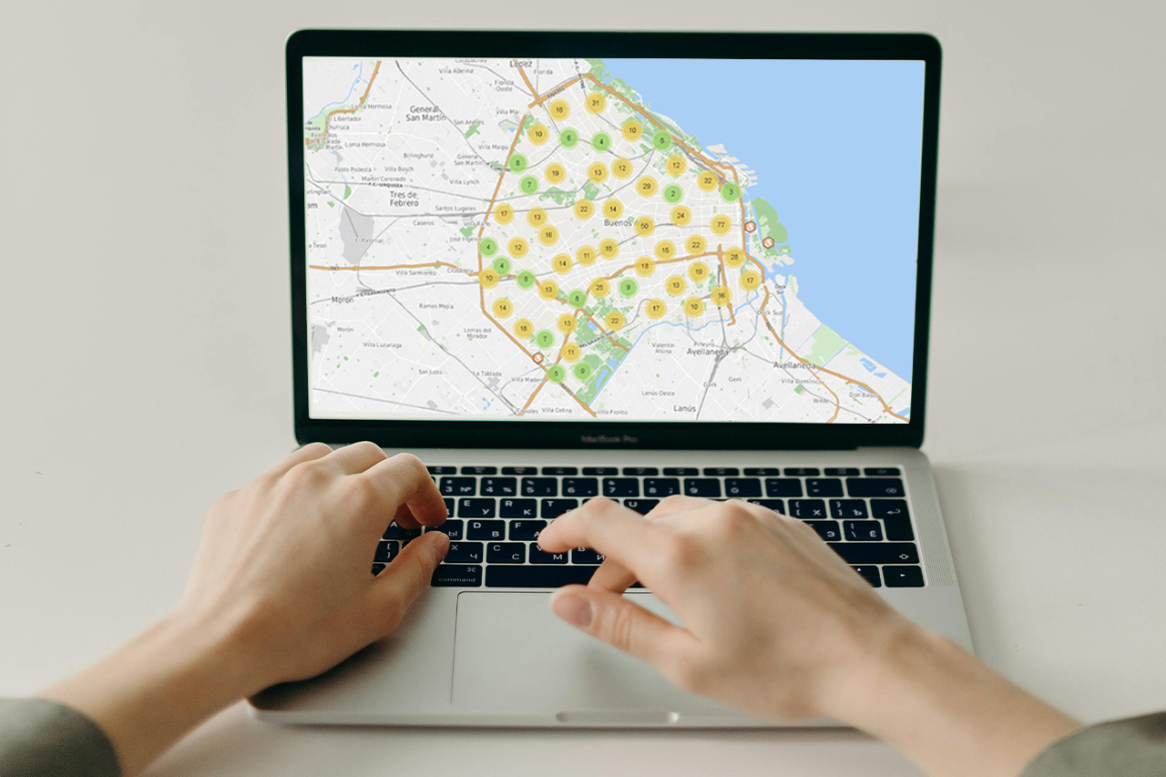 Persona usando una computadora portátil que muestra en pantalla un mapa digital con recursos geolocalizados en la Ciudad.