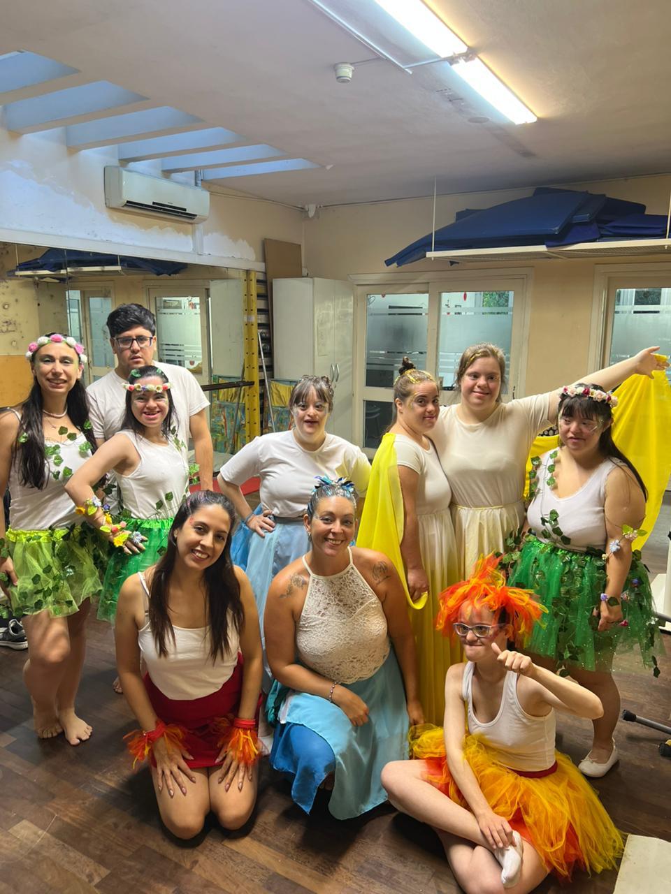 Participantes con vestuario colorido durante una actividad artística en un espacio de ensayo.