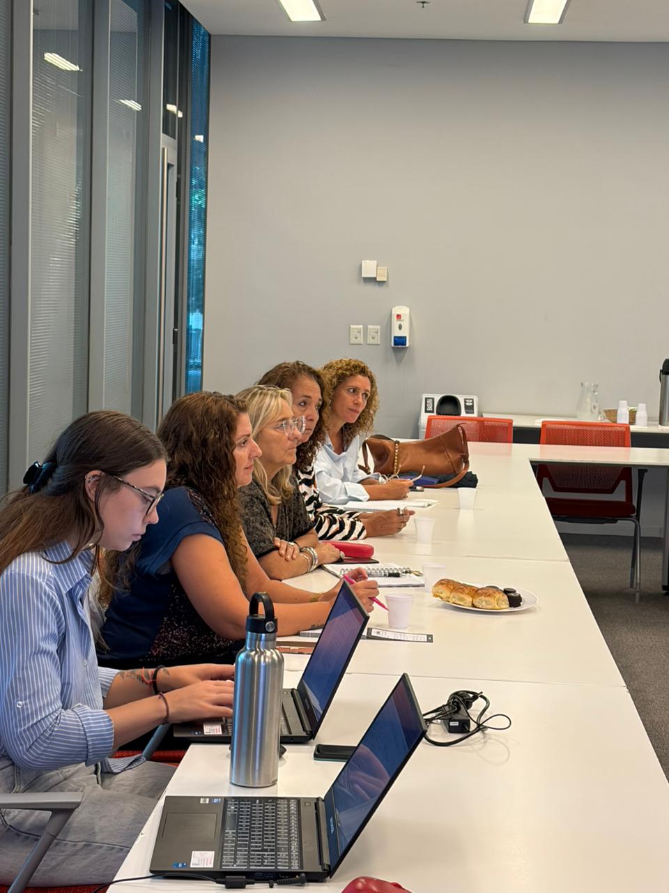 Participantes de la mesa de trabajo toman notas y utilizan computadoras durante el encuentro en el marco de la iniciativa sobre accesibilidad universal.