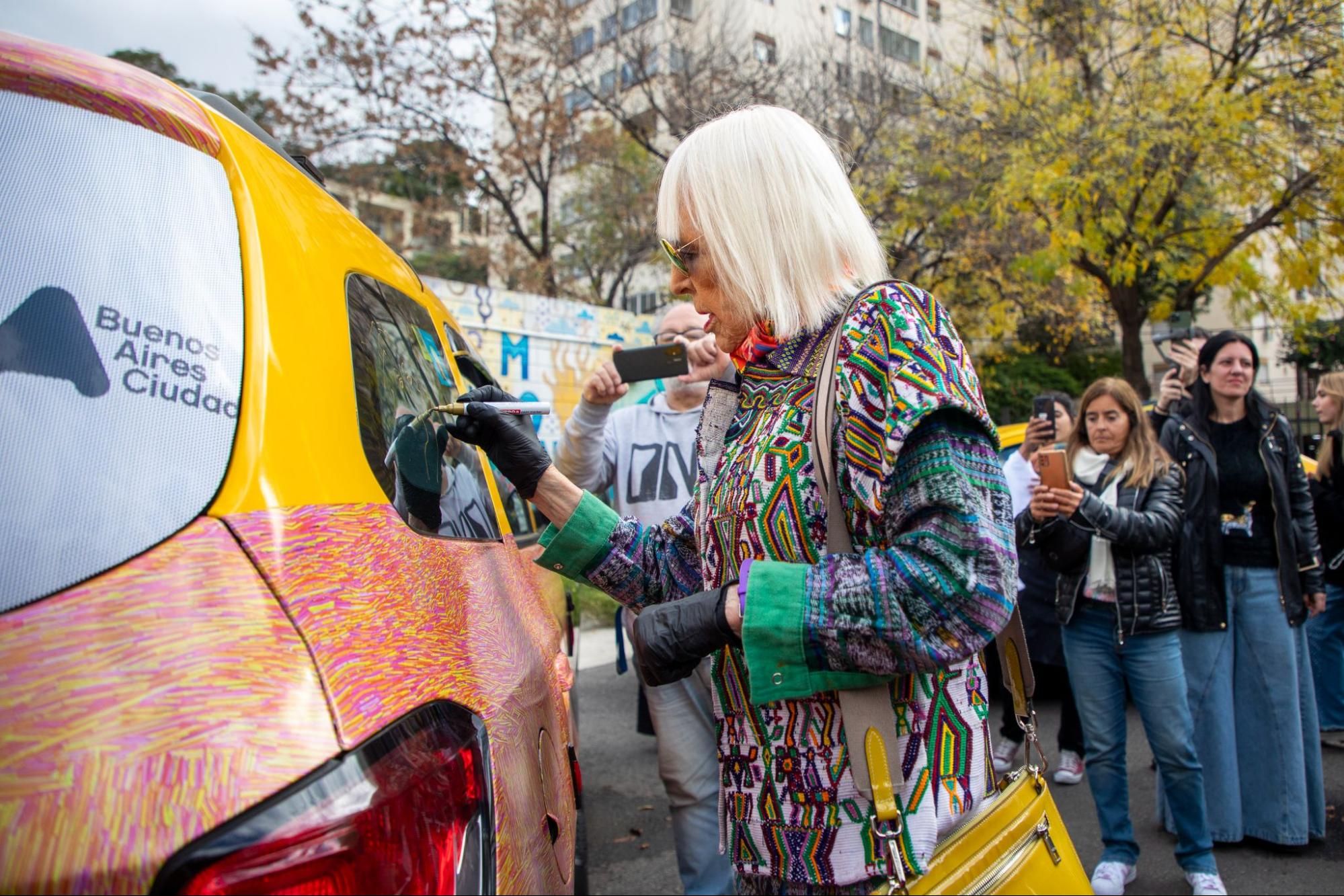 Marta Minujín firmando su intervención