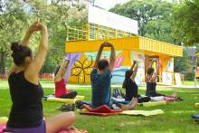 Personas sentadas en el pasto, el un parque haciendo gimnasia
