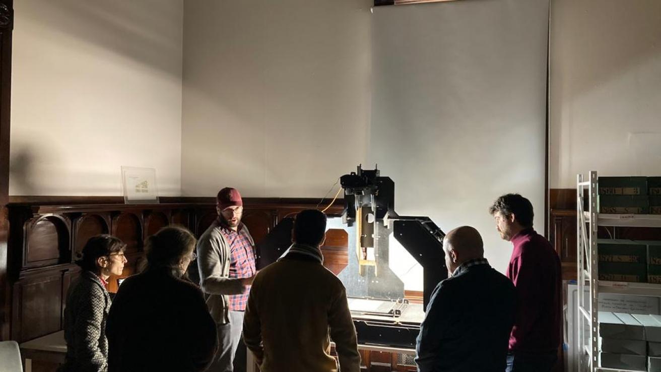 Gente mirando un escáner del archivo histórico de la ciudad de buenos aires 