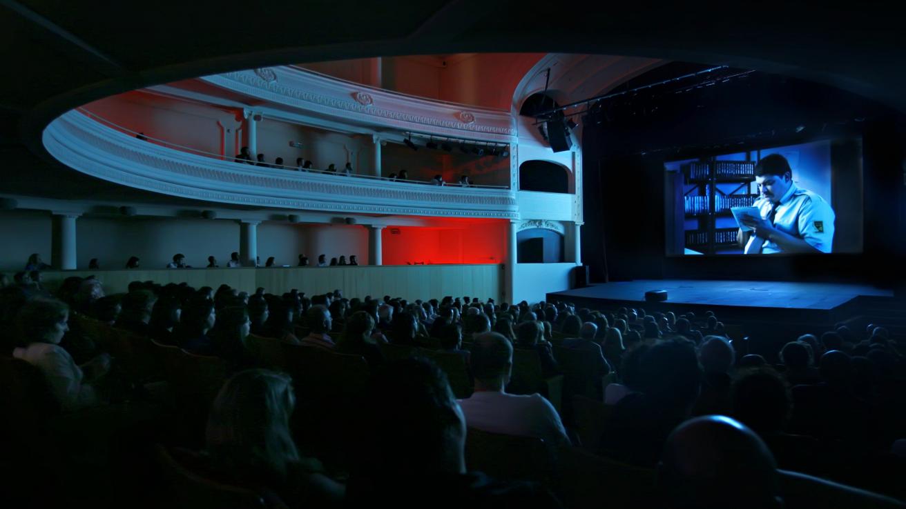 Proyeccion de pelicula en sala de cine, sala llena de espectadores