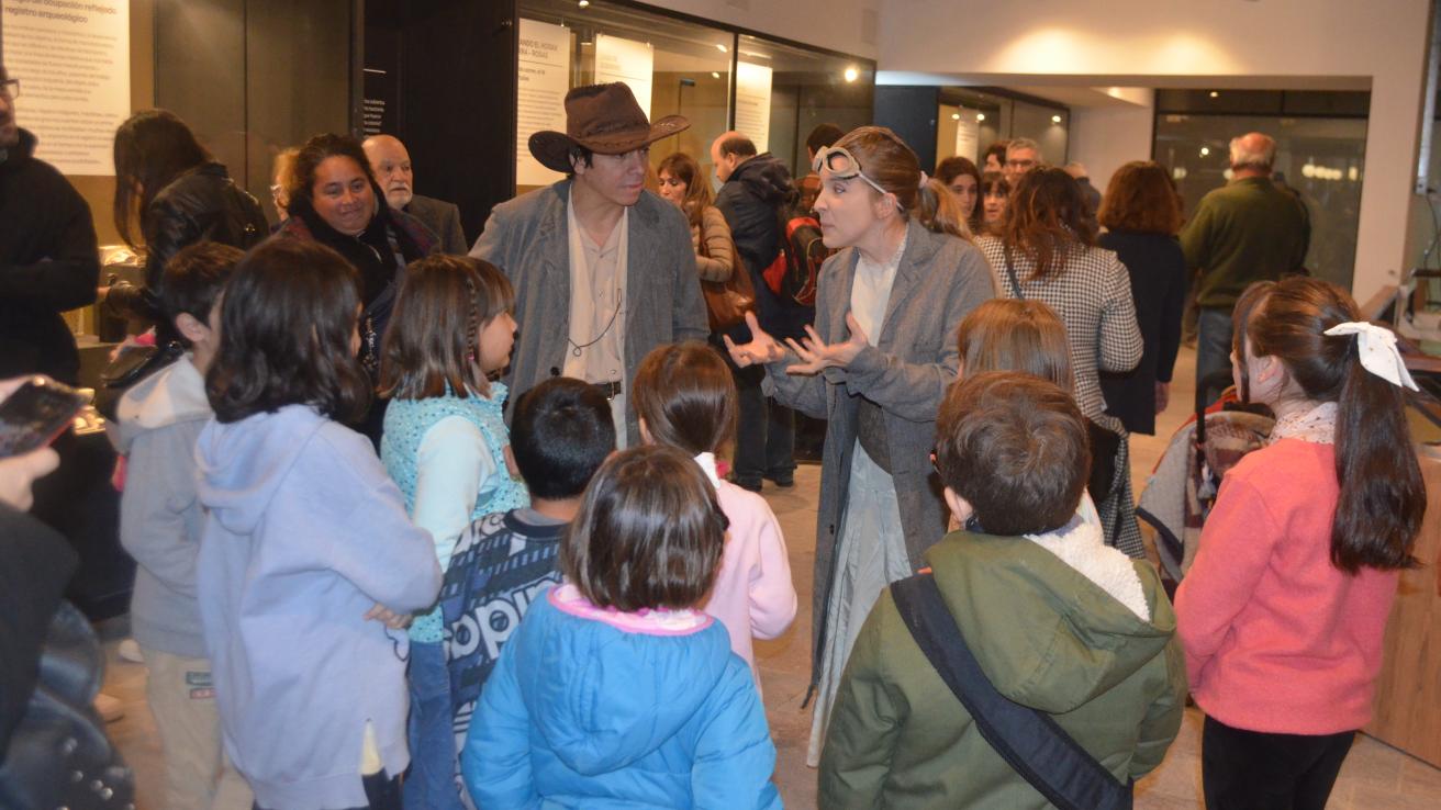 niños en ronda escuchando a dos personas que hablan