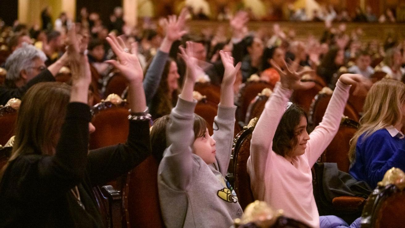 Fotografia de las personas haciendo saludo silencioso dentro del teatro colon