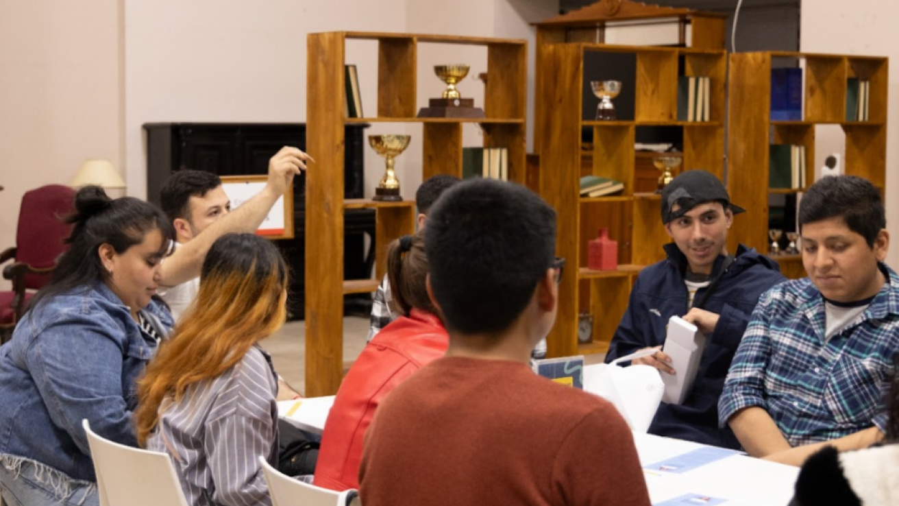 Personas sentadas en una mesa realizando una actividad