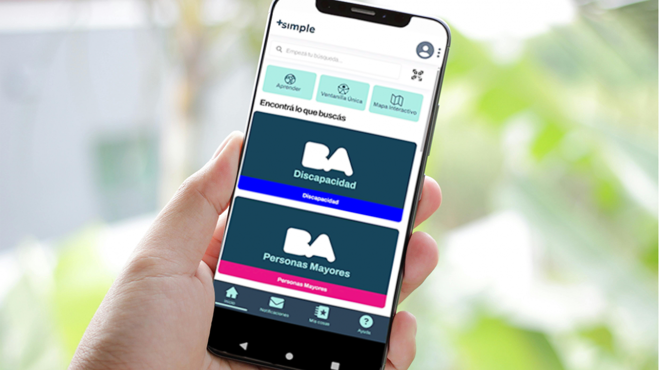 Persona sosteniendo un celular con la app Club+Simple abierta en la sección de Discapacidad y Personas Mayores