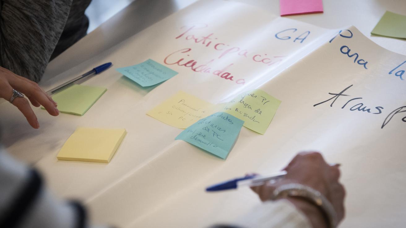 Manos escribiendo sobre una cartulina
