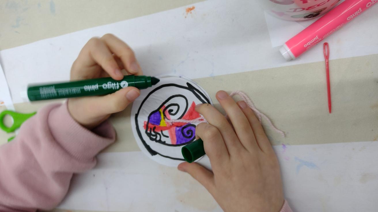 Manos de niño/a pintando con fibra de color