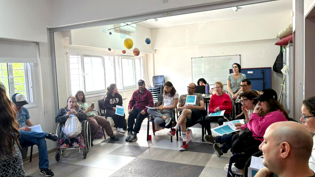 Salón de Fundación Caminos durante el taller de educación financiera ‘Cuentas Sanas’, con participantes reunidos en ronda en un ambiente luminoso y de trabajo colaborativo.