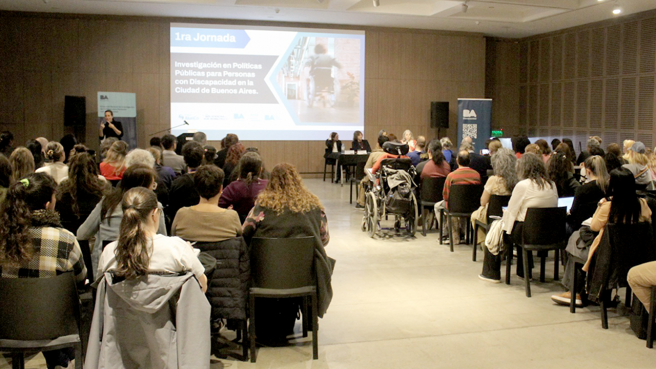 Público asistente en el auditorio del Museo de Arte Moderno durante la jornada sobre políticas públicas y discapacidad, con panelistas al frente junto a intérprete de Lengua de Señas Argentina.