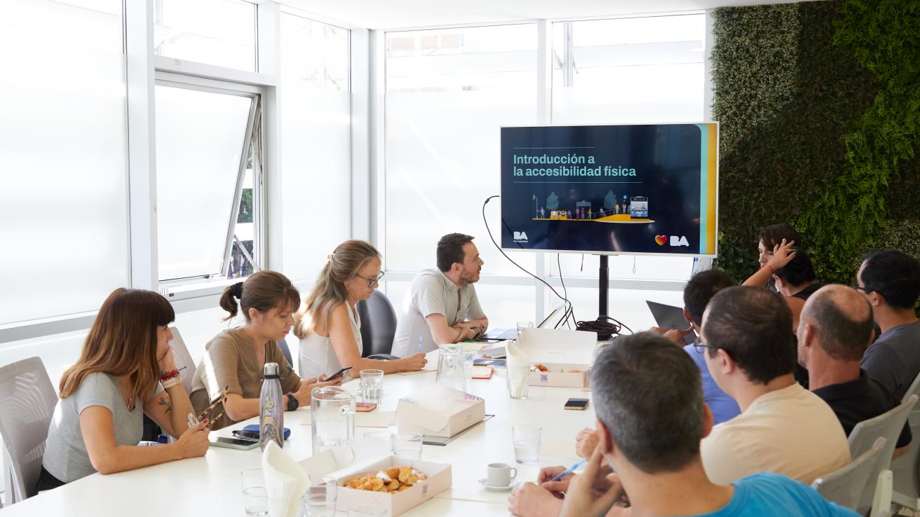 Equipos técnicos de diferentes comunas participan de la capacitación sobre accesibilidad física, con una presentación proyectada en pantalla durante la jornada.