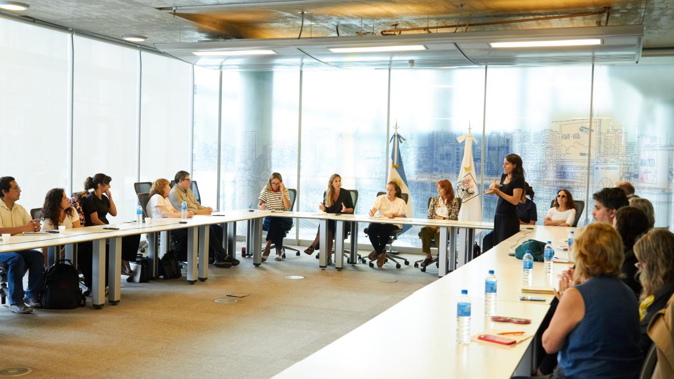 Reunión del CCH en la sede del Gobierno de la Ciudad, con representantes de organizaciones sentados alrededor de una mesa en U y una intérprete de Lengua de Señas Argentina durante la jornada.