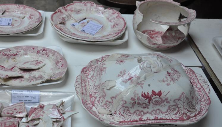 Platos antiguos y piezas arqueologicas sobre una mesa 