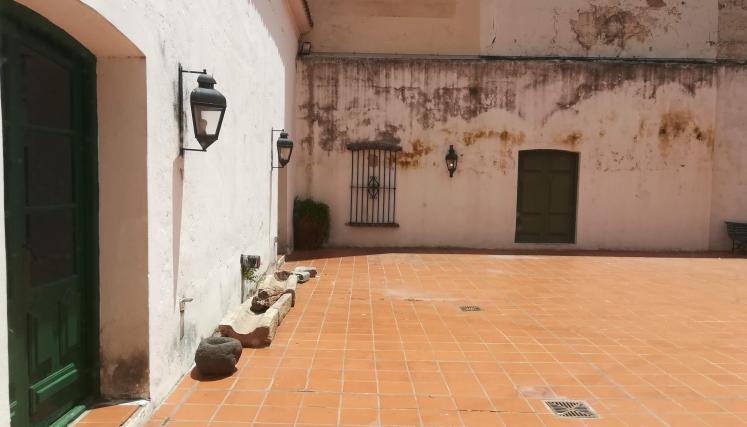 Interior de una casa con piso naranja y paredes con moho 