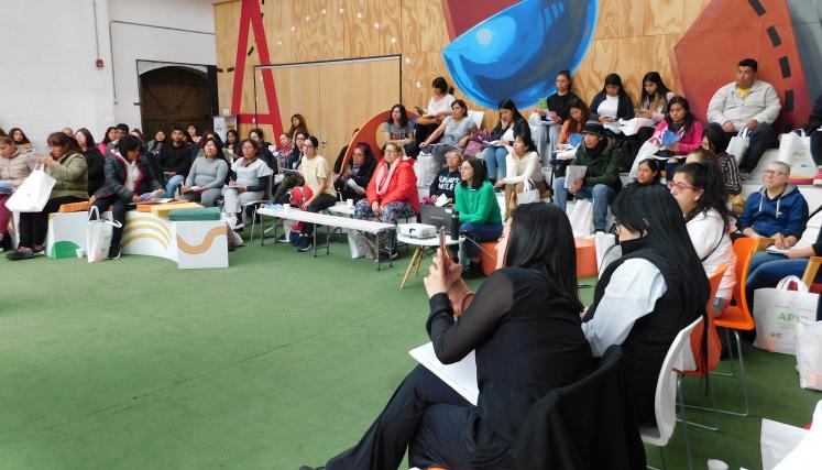 Fotografía tomada en lateral derecho del grupo de APVIS en formación. En ella se encuentran todos sentados y cada uno con acciones distintas donde destaca una mujer tomando fotografía a la presentación de PPT. 