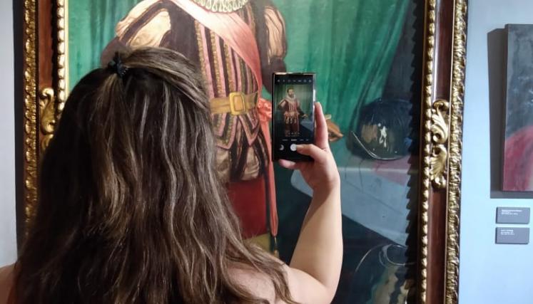 chica sacando foto a un cuadro