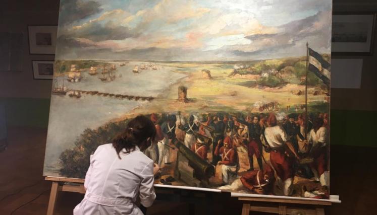 mujer restaurando cuadro