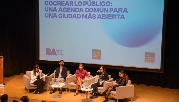 Panelistas del primer panel sentados debatiendo