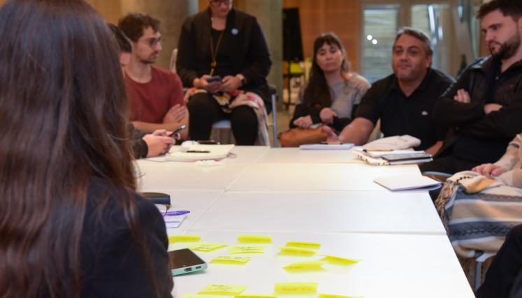 Personas intercambiando opiniones alrededor de una mesa