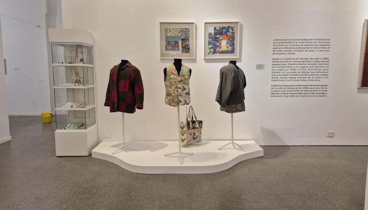 Imagen de sala. En el centro se exhiben tres maniquíes con piezas textiles: una campera a cuadros, un chaleco con estampado floral y una chaqueta gris. Abajo, un bolso estampado. Detrás, se ven dos cuadros enmarcados con diseños textiles. A la izquierda, una vitrina con objetos y documentos. A la derecha, un texto curatorial de la muestra..