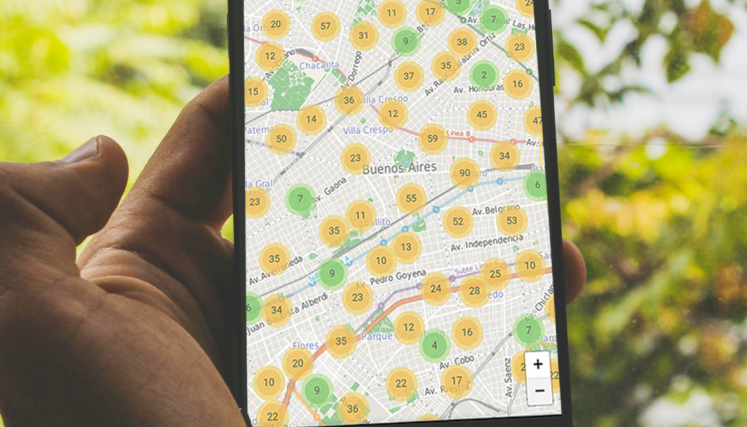 Persona sosteniendo un teléfono celular que muestra en pantalla el mapa colaborativo con recursos accesibles en la Ciudad.