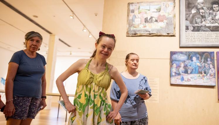 Personas mirando una exposición, entre ellas una nena con síndrome de Down