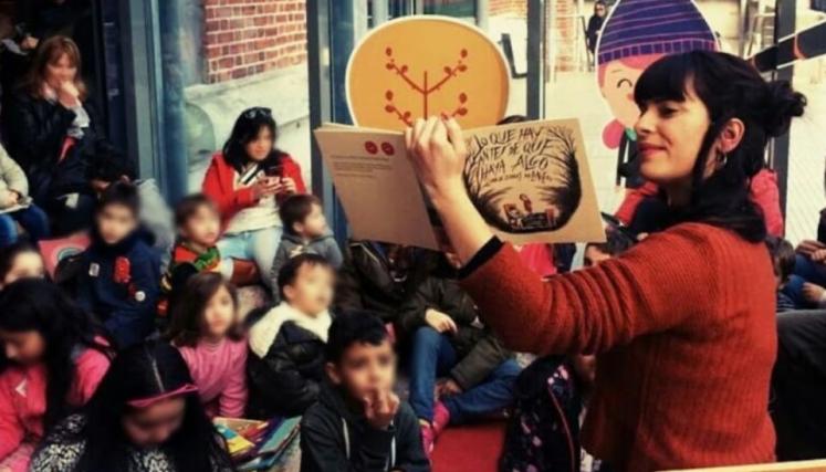 Mujer leyendo un libro a nenes