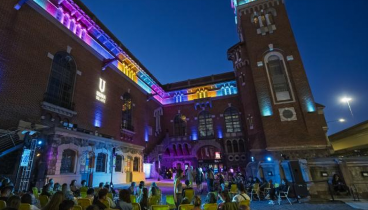 Personas sentadas en sillas mirando una película proyectada