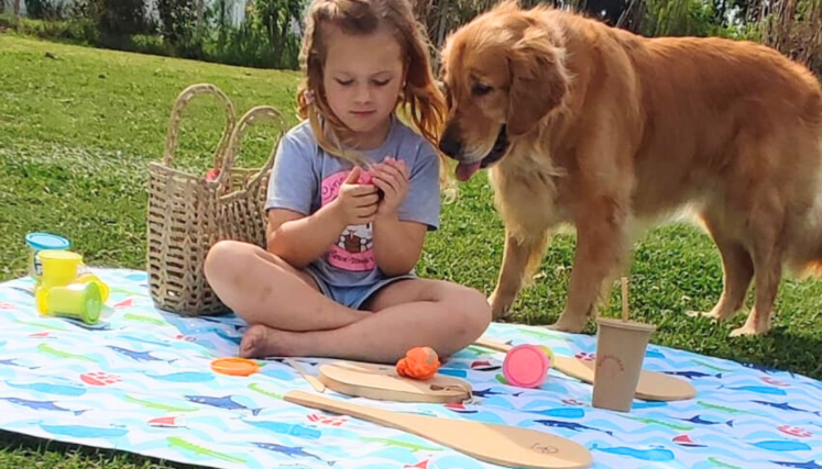 Niñas jugando con perro en un parque 