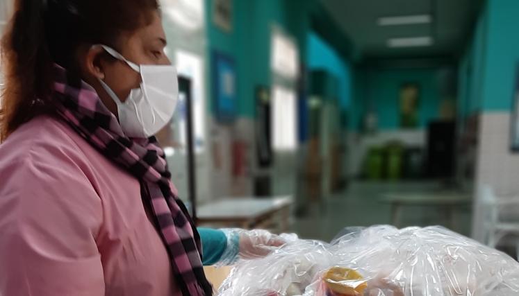 docente entregando canasta escolar nutritiva